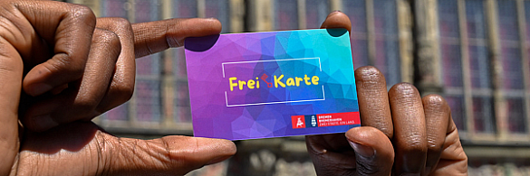 Die neue FreiKarte wird von zwei Händen in die Luft gehalten.